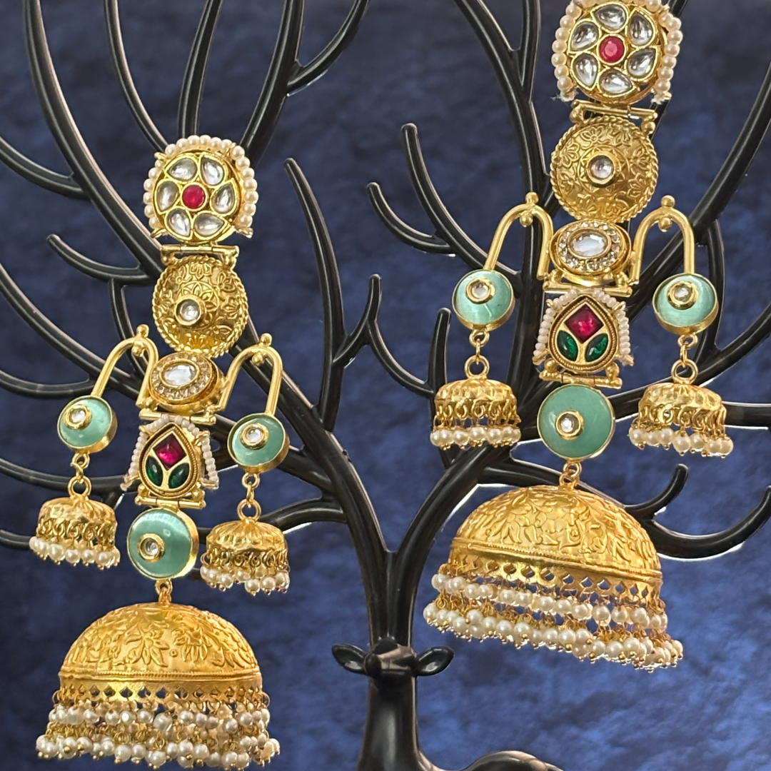 Gold-toned jhumka with layered design and pearl accents