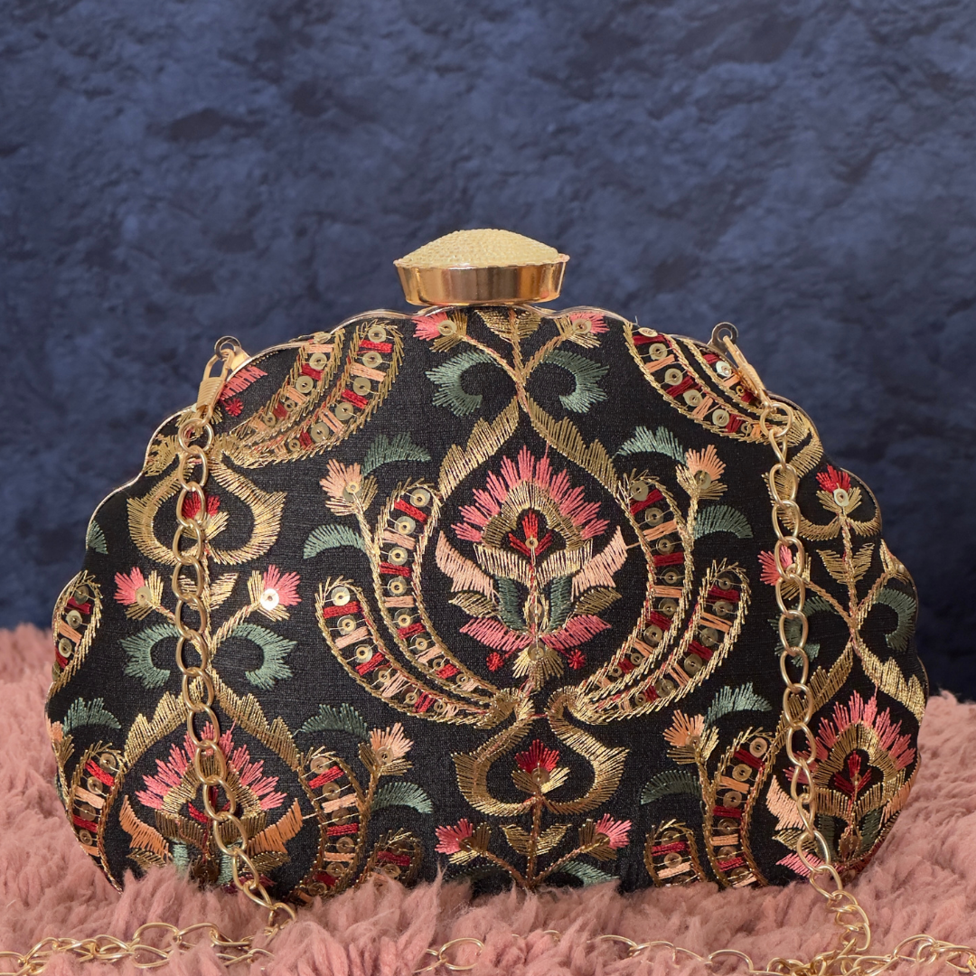 Elegant black clutch with intricate floral embroidery and a gold chain, perfect for a regal touch
